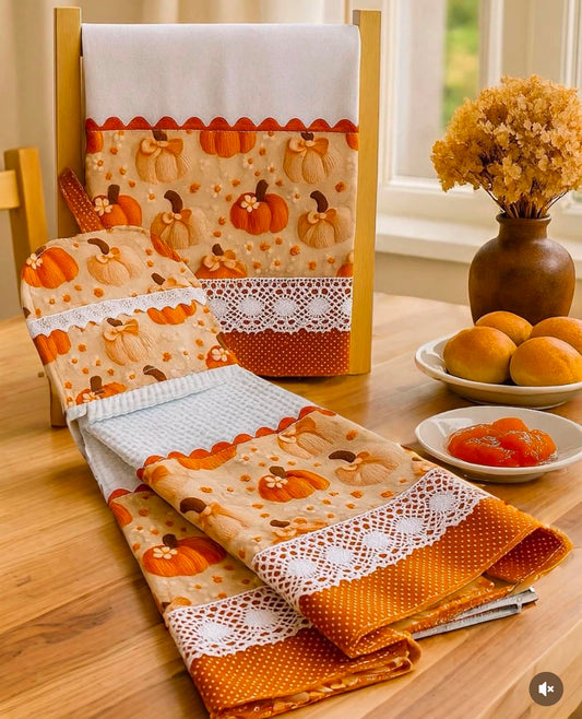 Rust pumpkin bow 3-piece set displayed on a wooden table showing flat weave towel, waffle weave hanging towel, and fabric basket with white crochet lace and rust polka dot trim