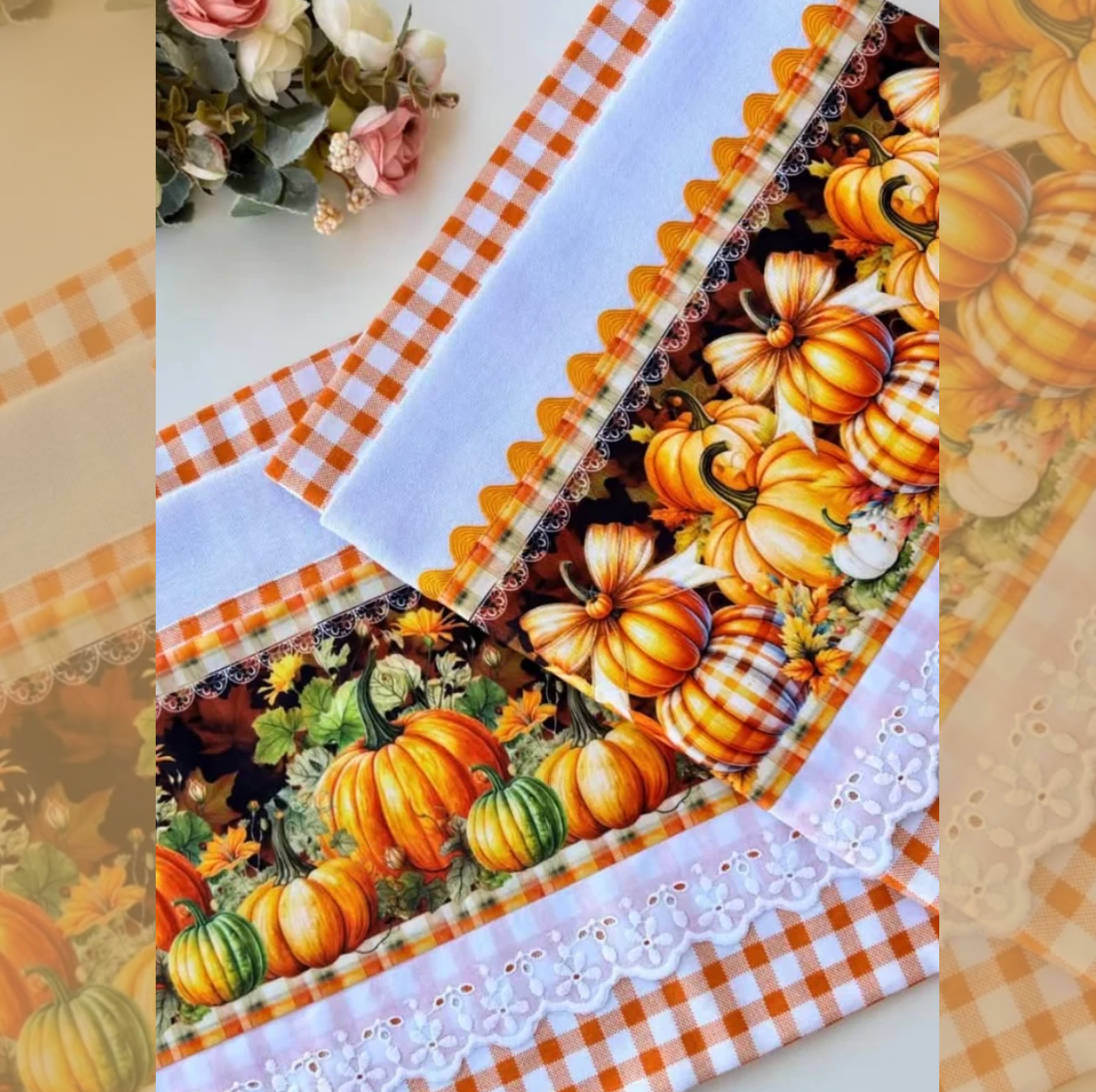Close-up of two white pumpkin patch tea towels with orange and green pumpkins, orange gingham borders, and scalloped white eyelet lace.