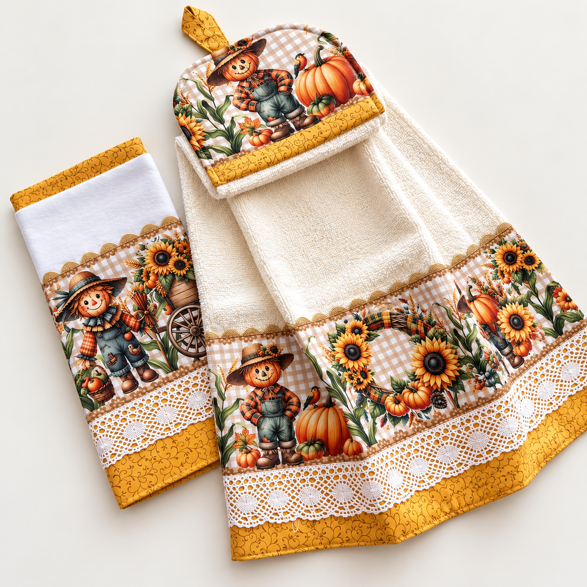 Fall kitchen towel set with scarecrow, pumpkin, and sunflower prints, mustard yellow borders, white lace trim, and a hanging towel.
