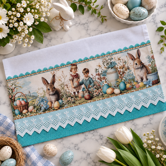 Vintage Easter Garden kitchen tea towel 20x30 flat lay on marble surface showing storybook print panel with children gathering Easter eggs alongside bunnies and spring florals, aqua polka dot trim with white eyelet lace border, surrounded by white tulips, speckled eggs, white bunny figurine, and spring flowers