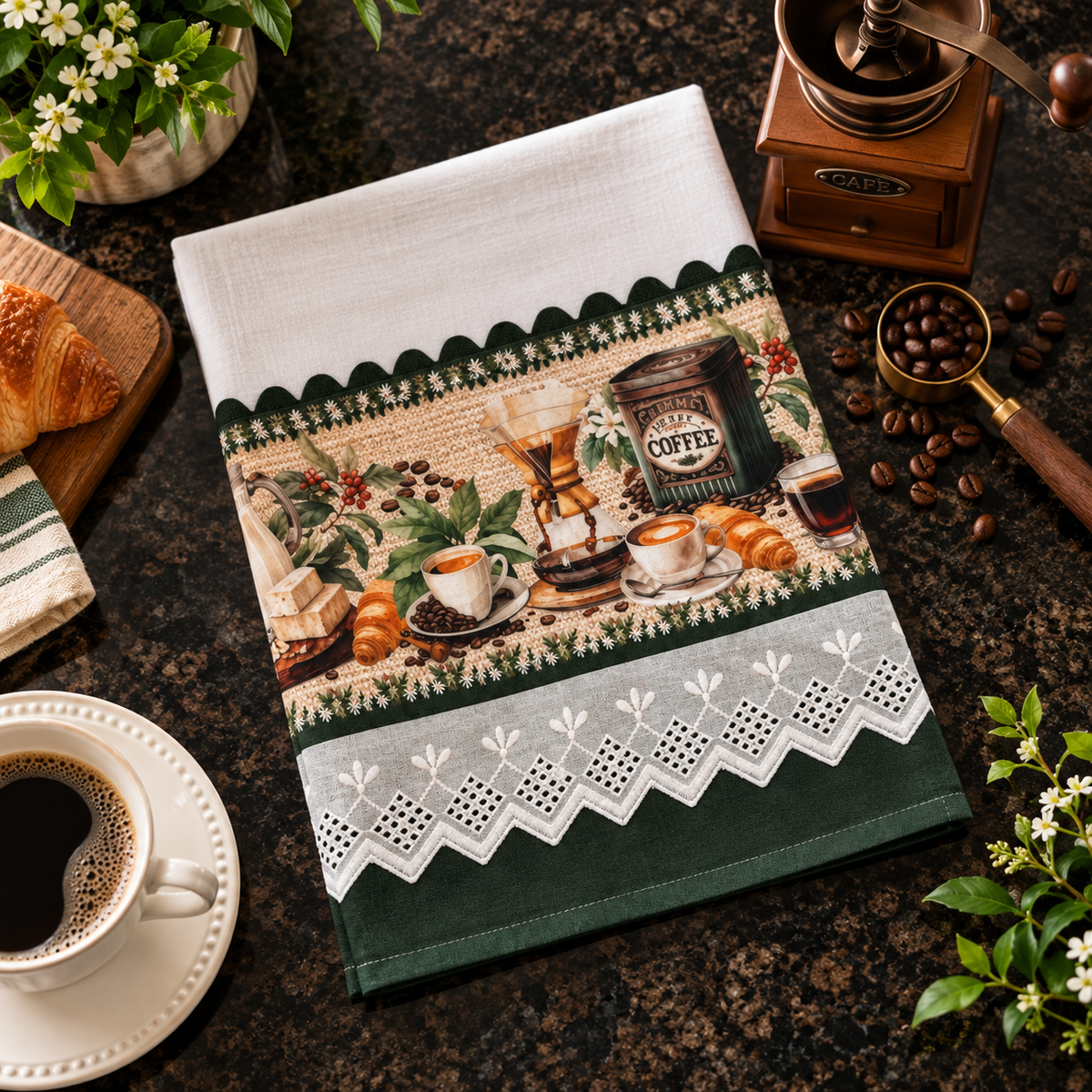 Coffee Lover's kitchen tea towel 20x30 flat lay on dark granite counter with vintage coffee grinder, espresso cups, croissant and coffee beans, green and white eyelet lace trim, coffee print panel with Cafe label and pour-over brewer