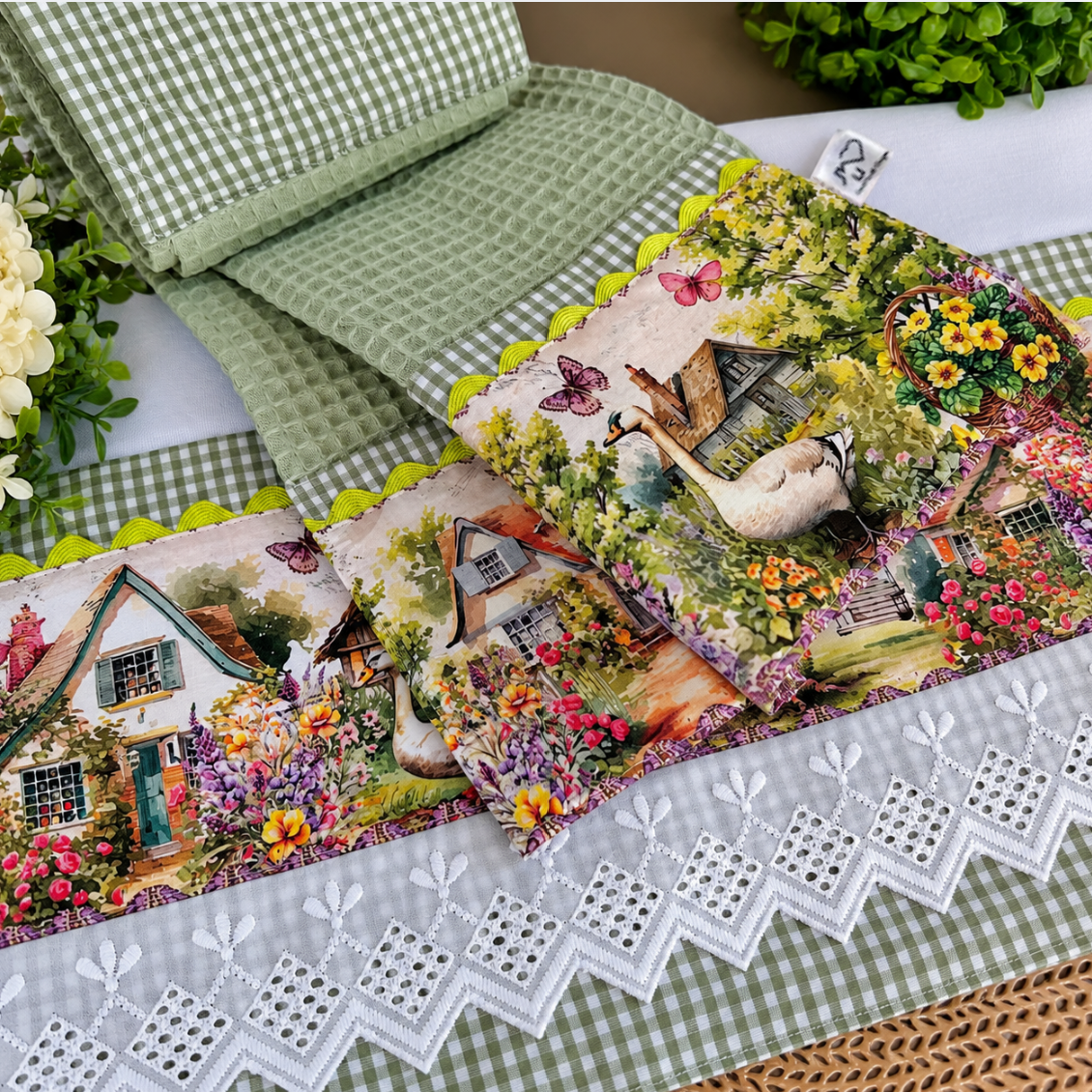 Farmyard two-piece set with a sage green waffle-weave hanging towel over a white tea towel, featuring goose and cottage garden prints, sage check and white eyelet lace.